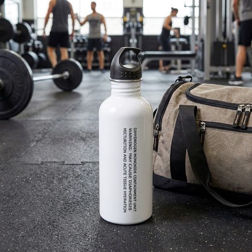 White laboratory-style water bottle featuring chemical warning text on a gym floor.